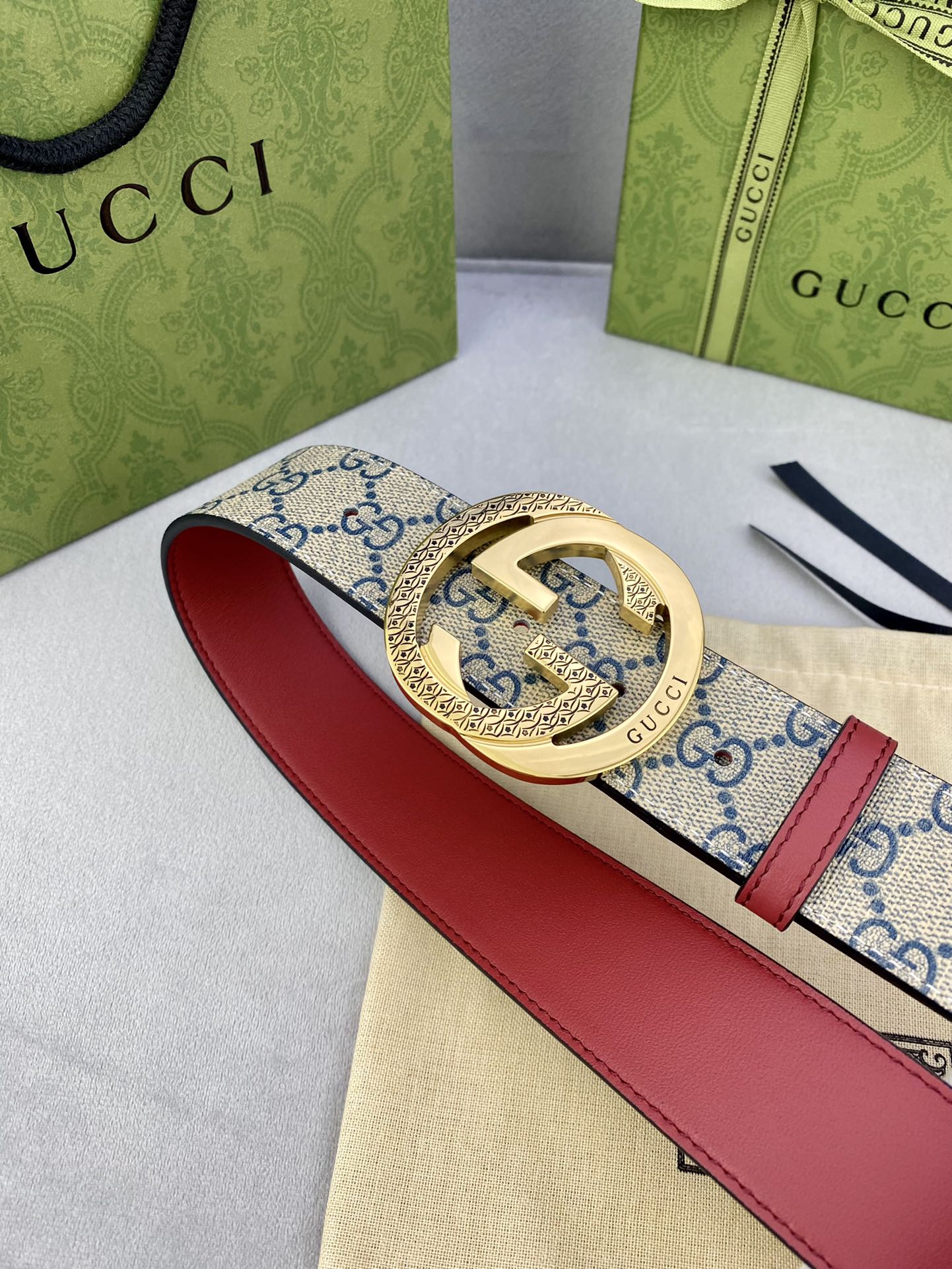 Logo-print belt with red leather strap and ornate gold-tone buckle