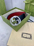 Gucci belt in green box with dark monogram strap, red trim, and silver buckle