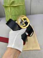 Gucci belt with dark leather and red strap, gold-tone double G buckle detail
