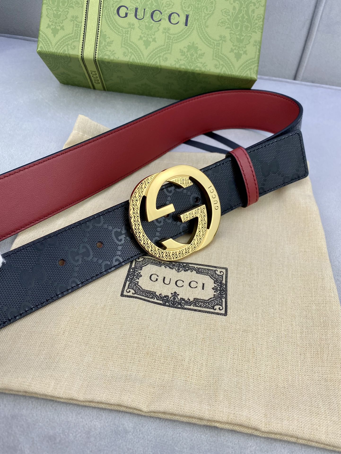 Gucci belt with dark leather and red underside, gold round double G buckle