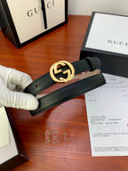Gucci belt with dark leather strap and gold interlocking G buckle, close-up