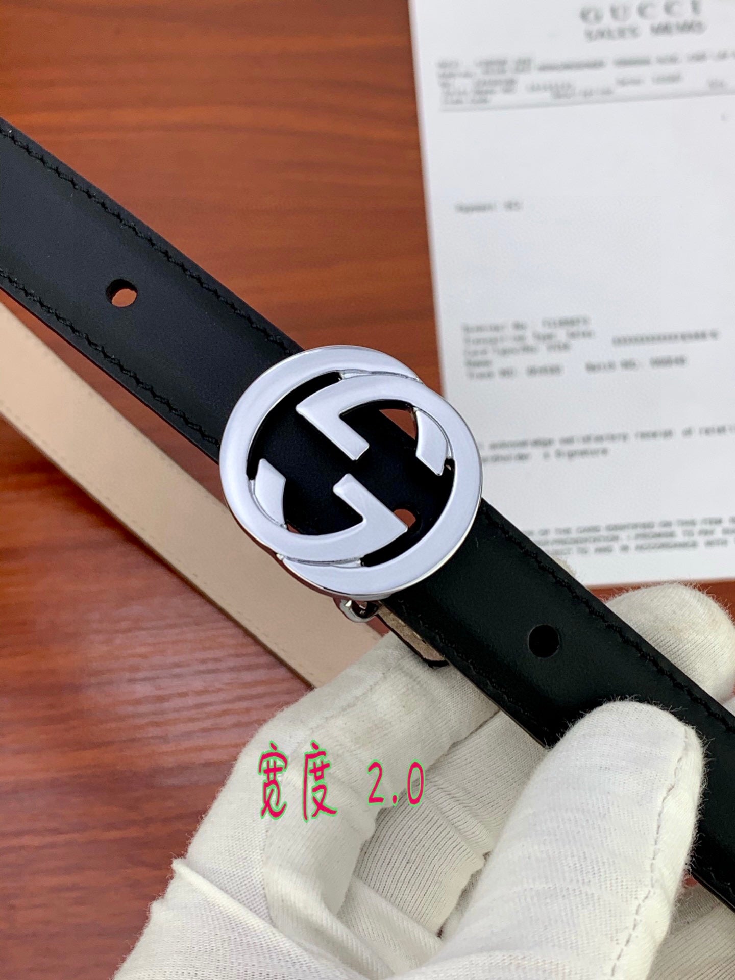 Gucci belt with dark leather strap and silver interlocking G buckle, close detail