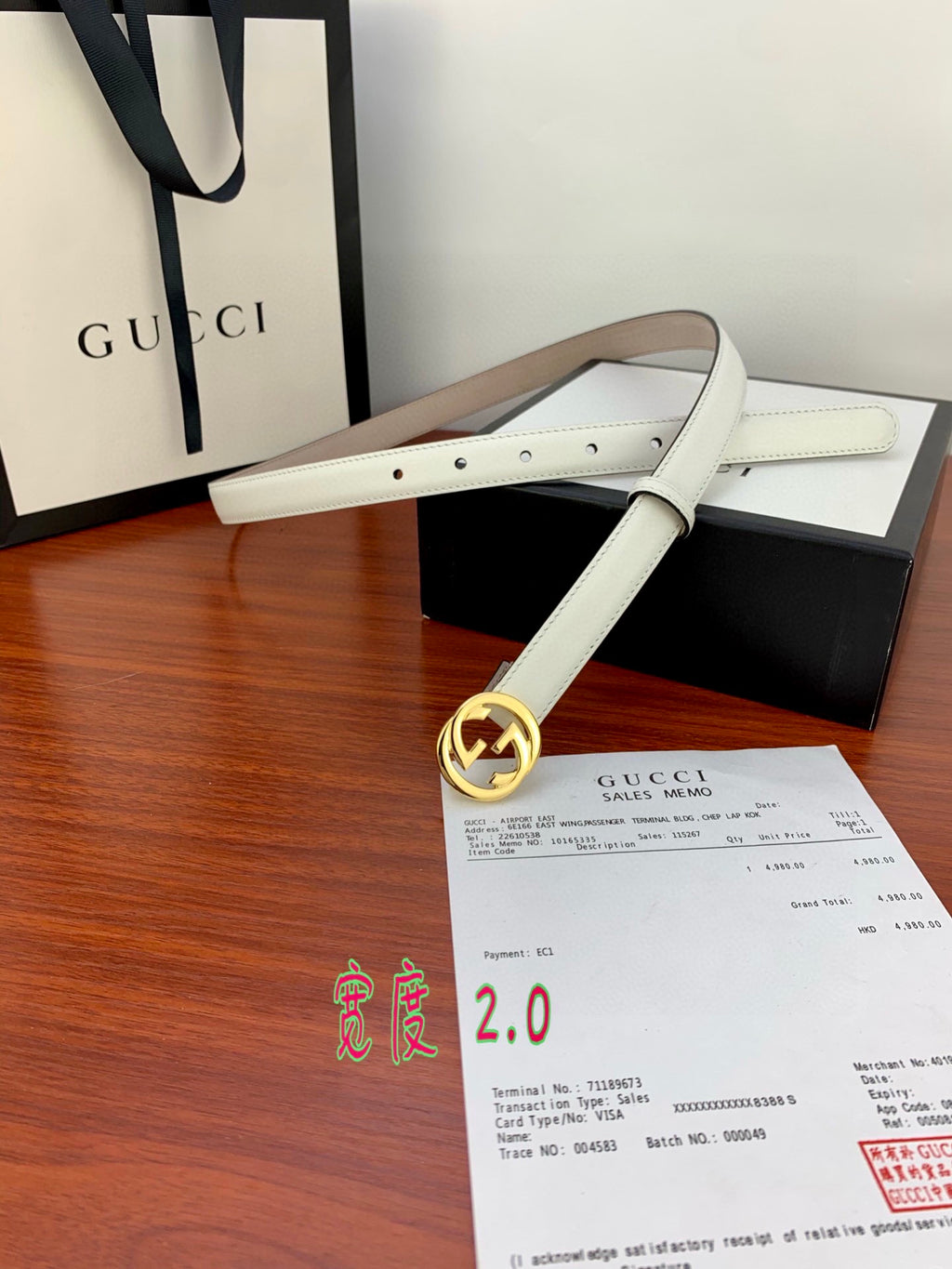 White leather belt with gold double-G buckle and two-row stitching along strap.