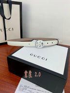 White leather Gucci belt with silver double-G buckle and punched strap holes.