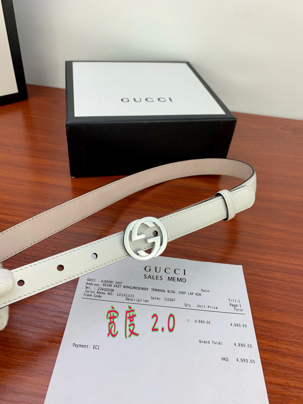White leather Gucci belt with silver double-G buckle and stitched strap edges.