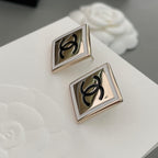 Chanel stud earrings close-up with square bezels and black CC logos