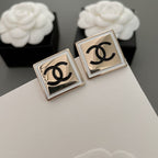 Chanel stud earrings, square bezel design with black CC logo, angled view