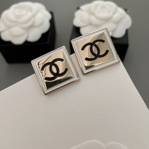 Chanel stud earrings, square bezel design with black CC logo, angled view