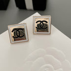 Chanel stud earrings with square settings and black CC logo, front view pair