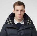 Burberry long hooded puffer jacket close-up with plaid hood lining and dark quilted fabric