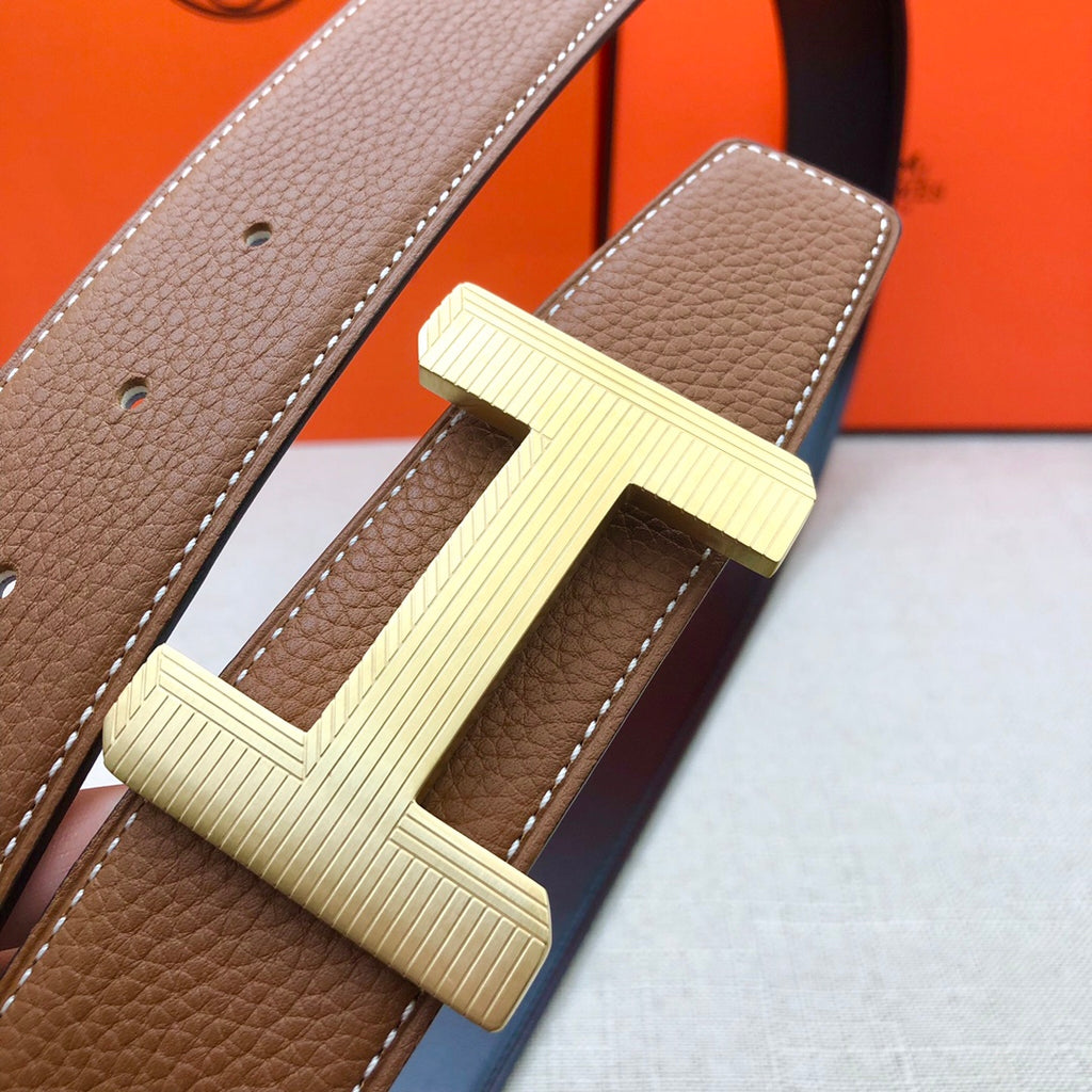 Brown leather belt close-up with cream H buckle and side holes