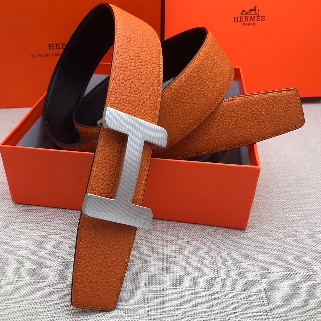 Hermes belt with orange leather strap and white-silver H buckle, adjustable holes