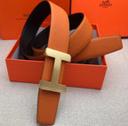 Hermes belt with orange leather strap and silver H-style buckle, adjustable holes