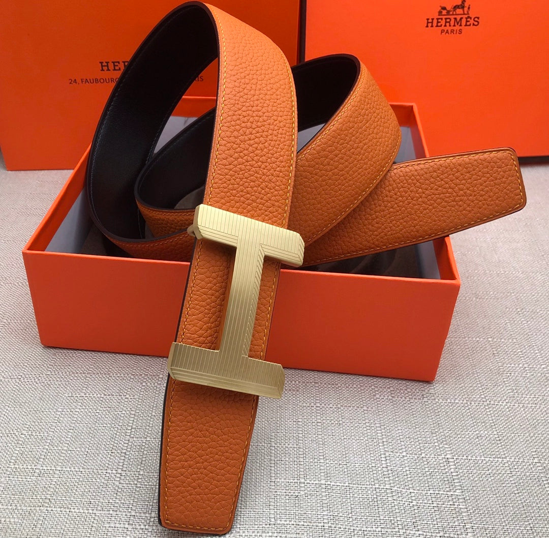 Hermes belt with orange leather strap and silver H-style buckle, adjustable holes