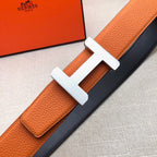 Hermes belt orange leather strap with silver H buckle on dark backing