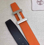 Hermes belt with orange leather strap and silver H buckle, black strap with holes