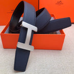 Leather belt with navy strap and silver-tone H buckle, rectangular double-stud keeper.