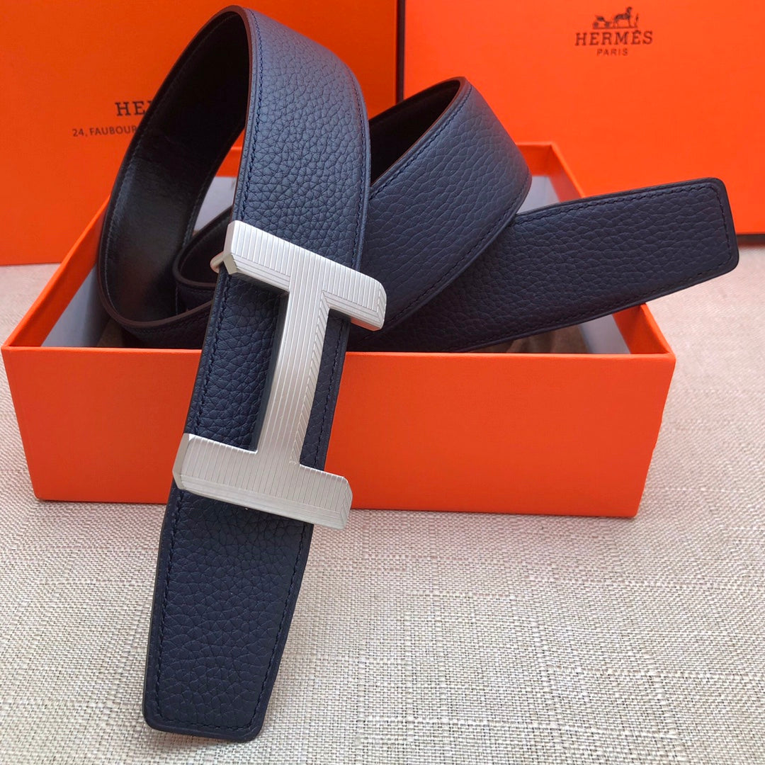 Leather belt with navy strap and silver-tone H buckle, rectangular double-stud keeper.