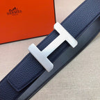 Leather belt detail: navy strap with silver-tone H buckle and textured leather grain.