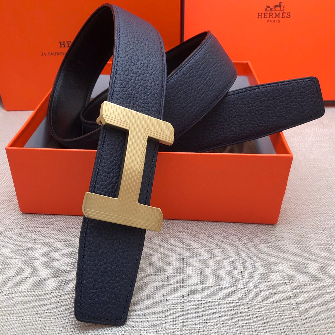 Leather belt with navy strap and gold-tone H buckle, rectangular double-stud keeper.