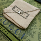 Lion head pendant necklace with silver chain on cream fabric pouch
