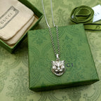 Lion head pendant necklace with silver chain on green accessory box