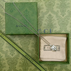 Lion head pendant necklace with silver chain resting on green gift box