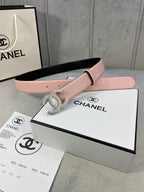 Chanel belt with light pink strap and rhinestone CC buckle, laid on boxes
