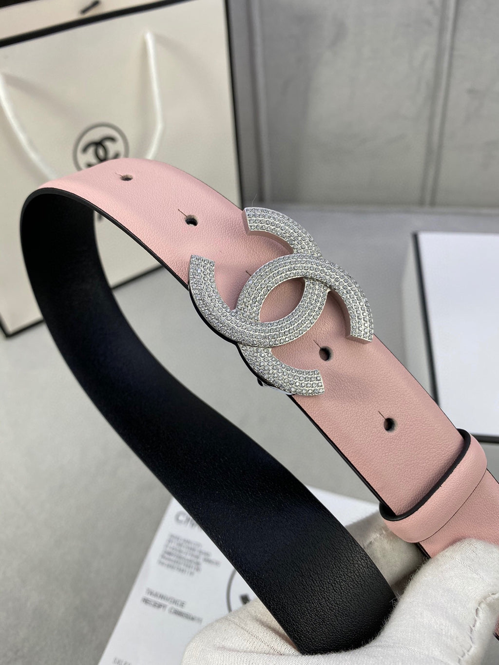 Chanel belt on black backing with light pink strap and silver rhinestone CC buckle