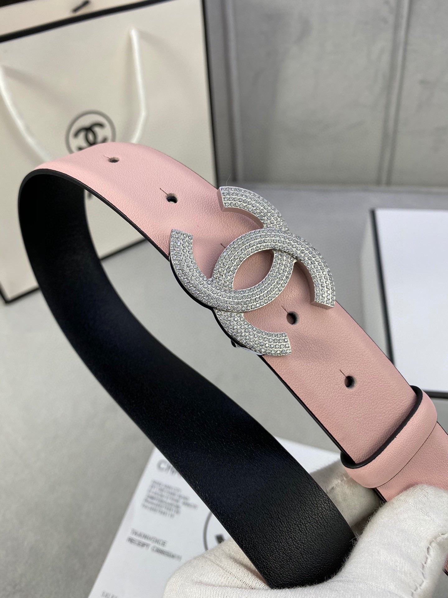 Chanel belt on black backing with light pink strap and silver rhinestone CC buckle