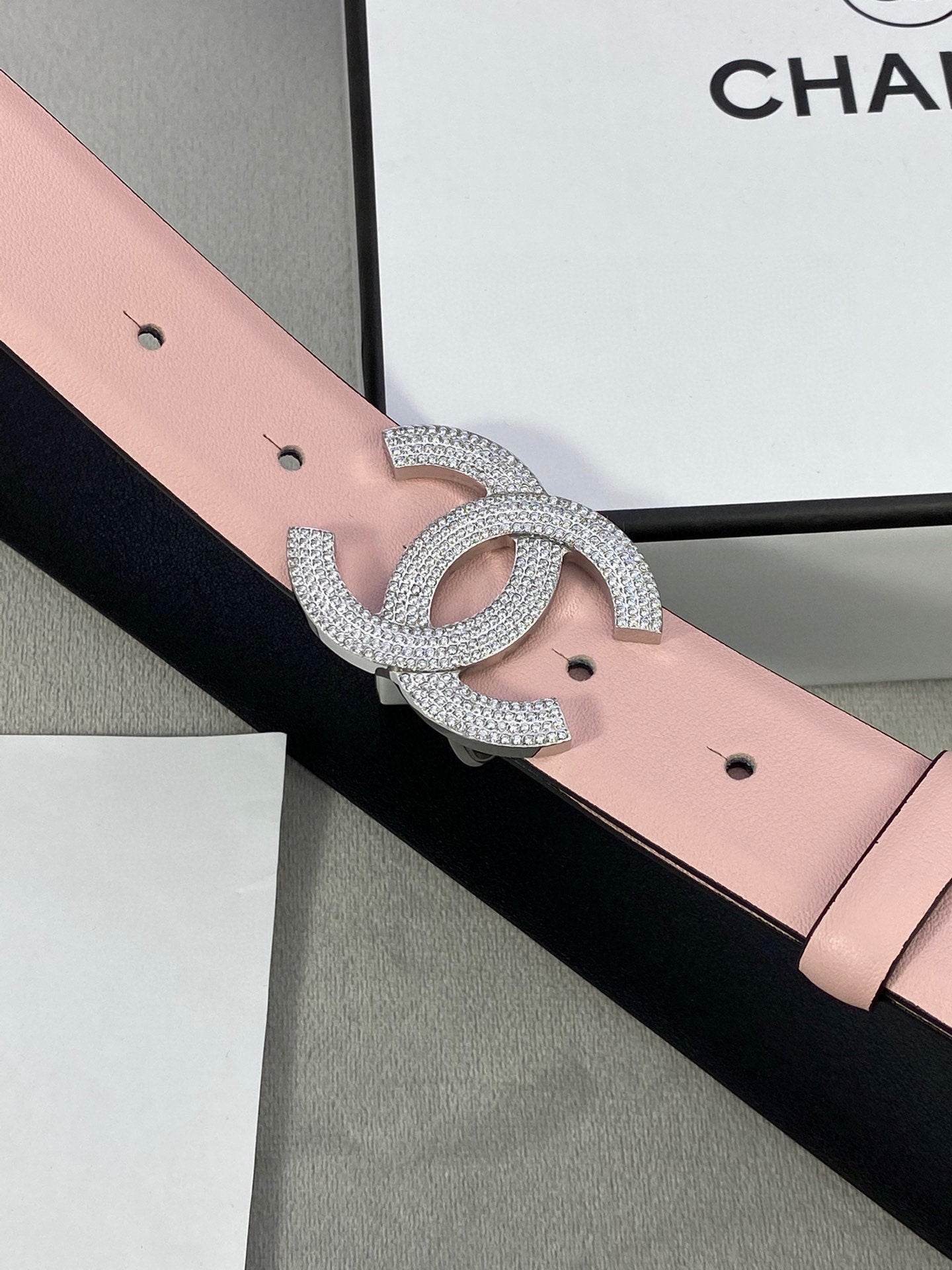 Chanel belt with light pink strap and silver rhinestone double-C buckle detail
