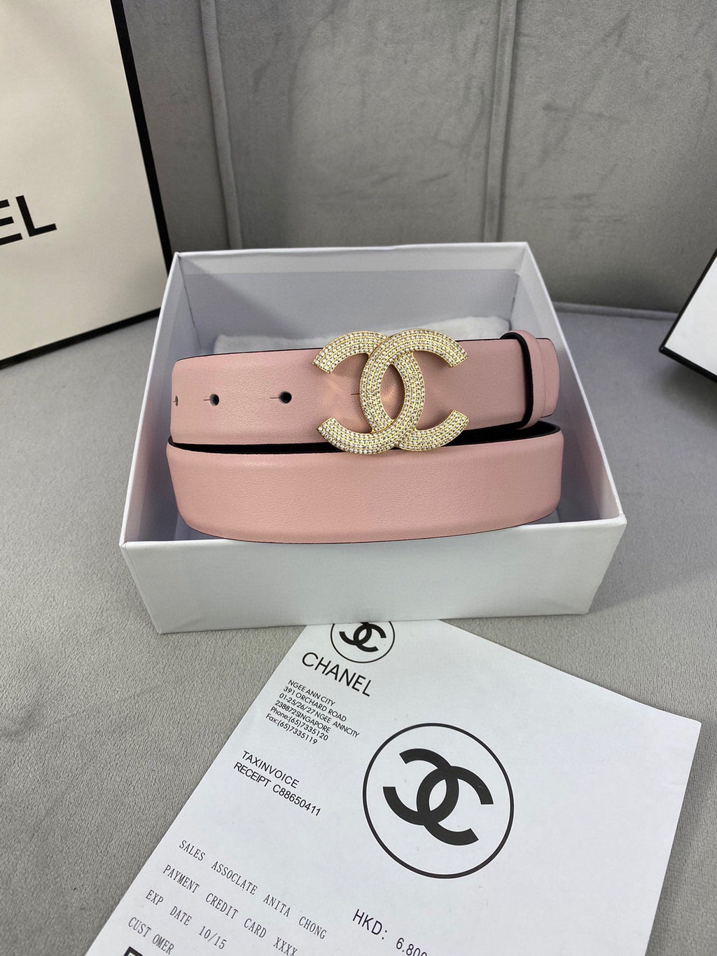 Chanel belt in light pink leather with rhinestone CC buckle, shown in gift box