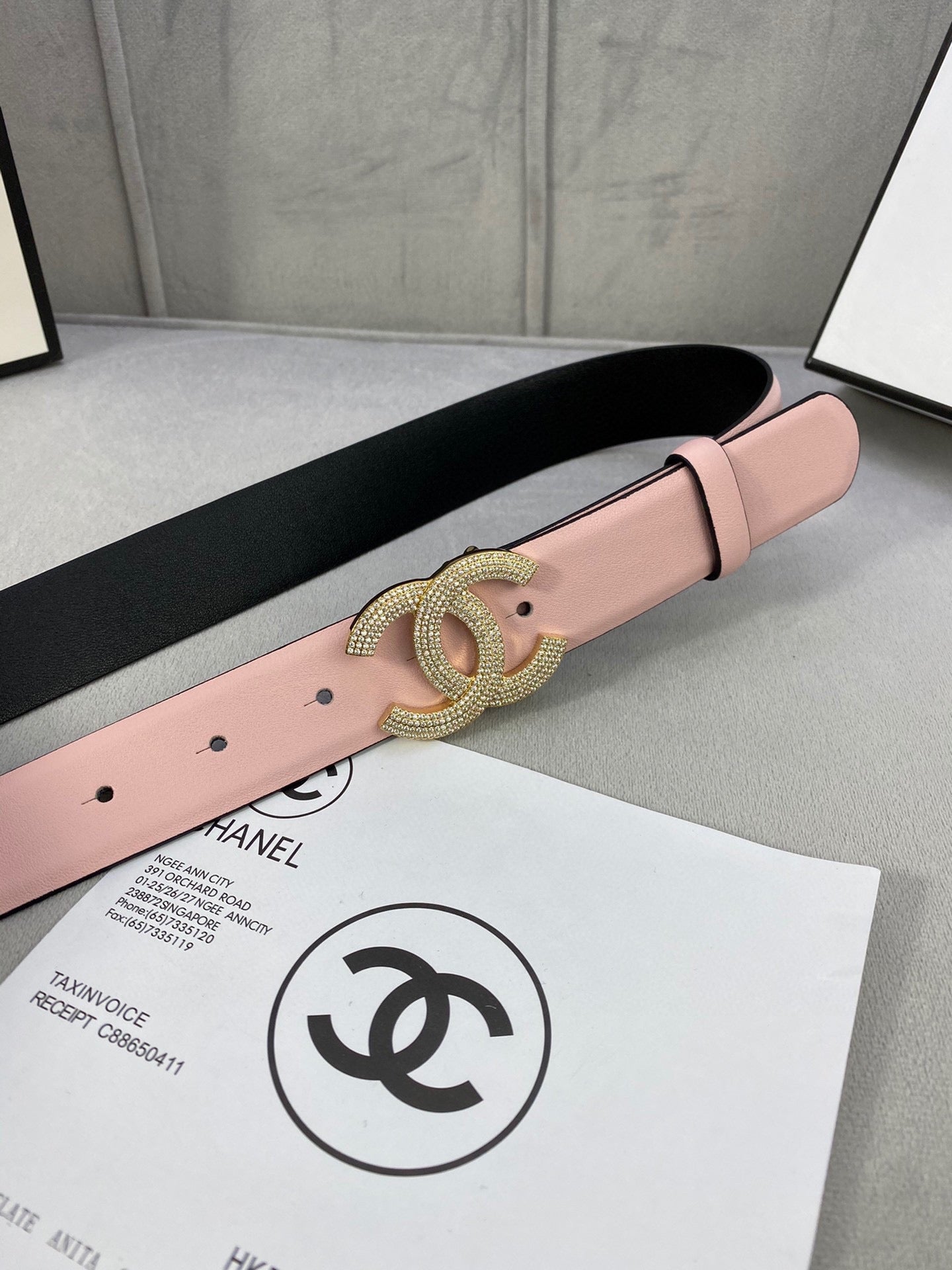 Chanel belt with light pink strap and rhinestone CC buckle, close-up