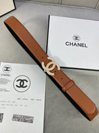 Tan leather belt with rhinestone CC buckle and gift receipt, on the floor.