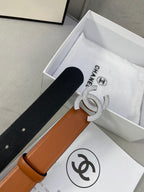 Black and tan leather belt with rhinestone CC buckle, shown with packaging.