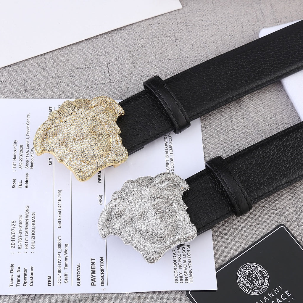 Black leather belt with gold- and silver-tone Medusa buckle medallions.
