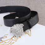 Black leather belt with gold-tone Medusa buckle on a coiled strap.