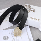 Black leather belt with gold-tone Medusa buckle, curved profile detail.
