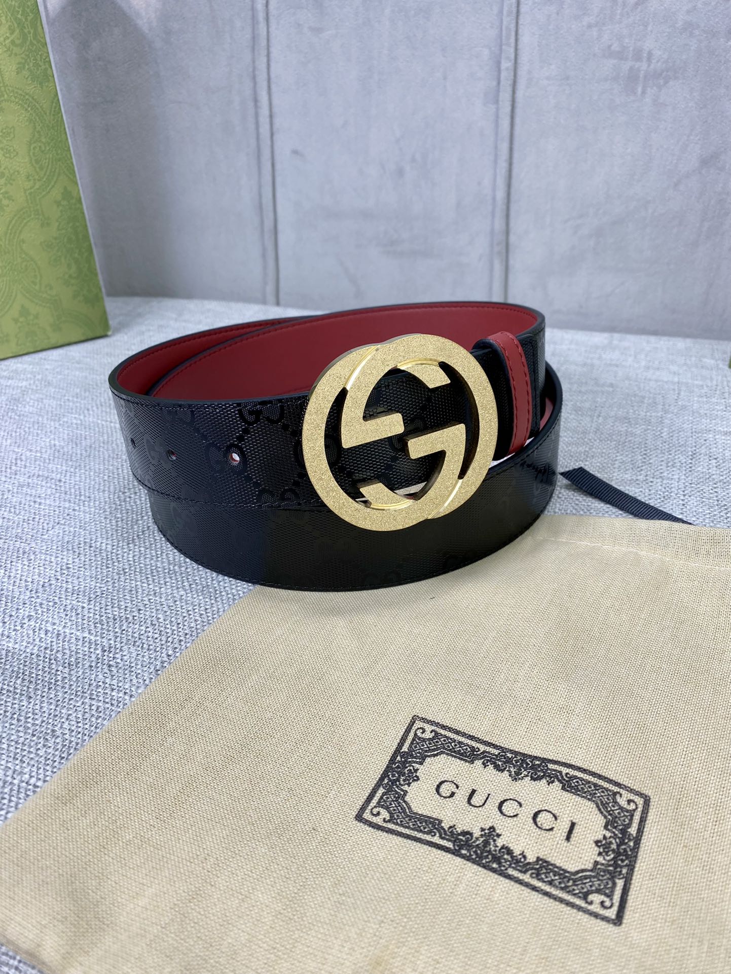 Gucci belt, black strap with gold double-G buckle and red underside lining