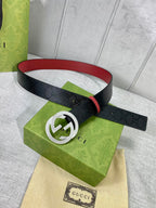 Gucci belt on display, black strap with red lining and silver double-G buckle