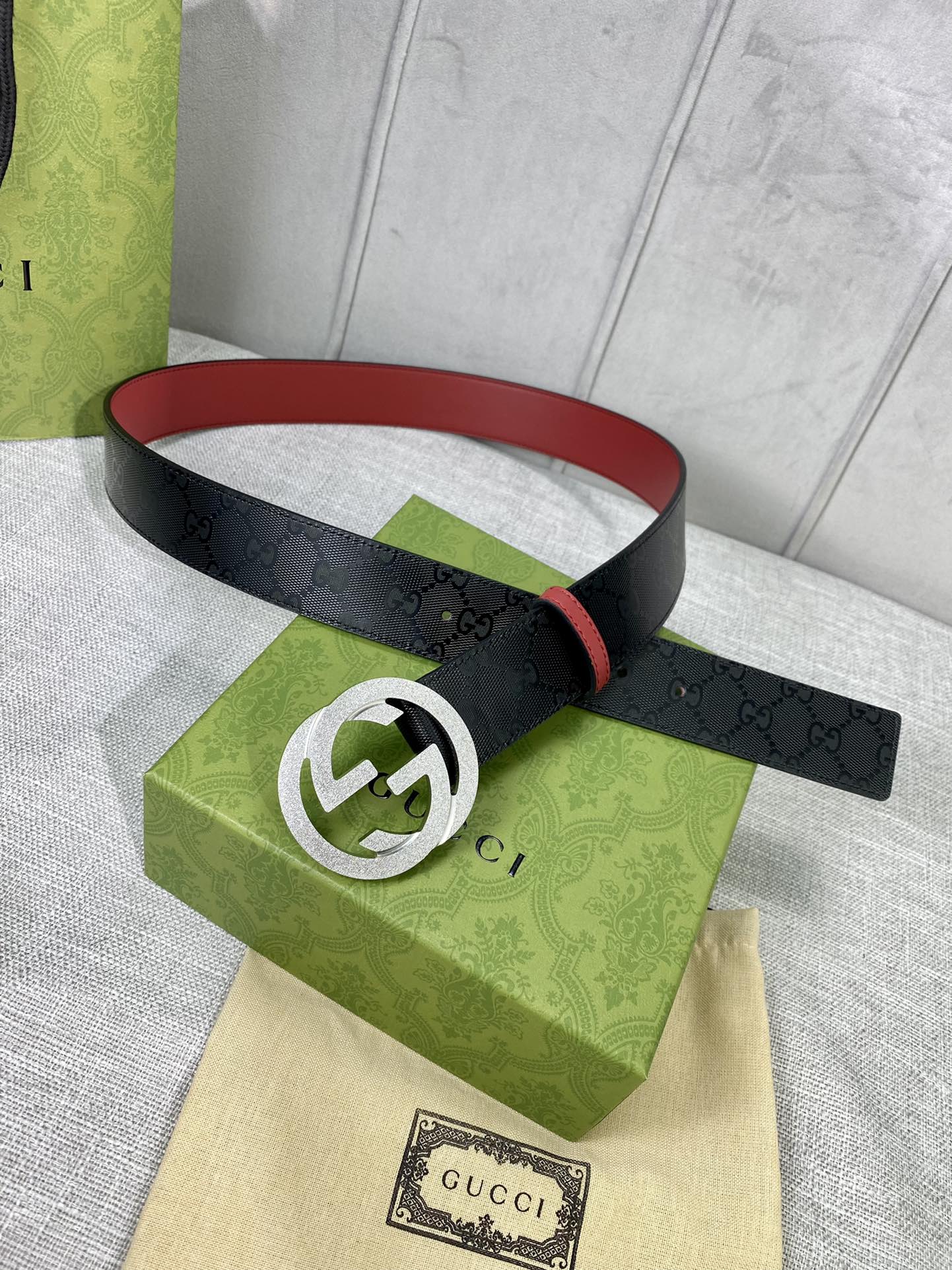 Gucci belt on display, black strap with red lining and silver double-G buckle
