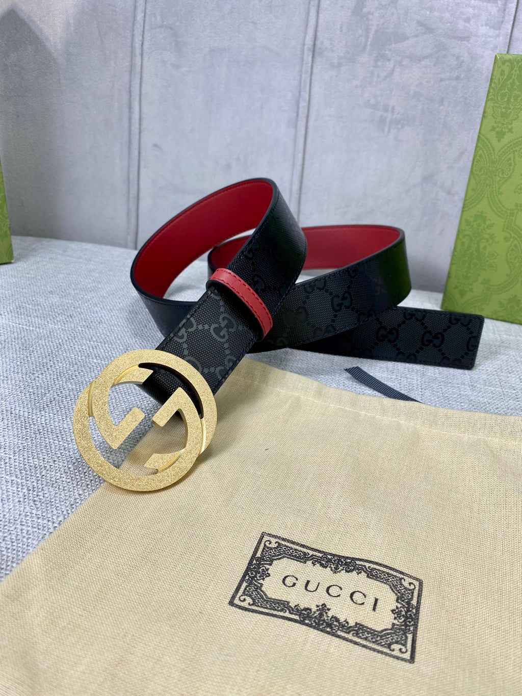 Gucci belt on display, black monogram strap with gold double-G buckle