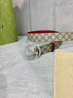 GG canvas belt with red leather edge and gold-toned interlocking buckle, coiled