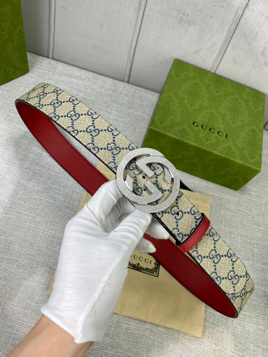 GG canvas belt with red leather edge and gold-toned interlocking buckle, laid flat