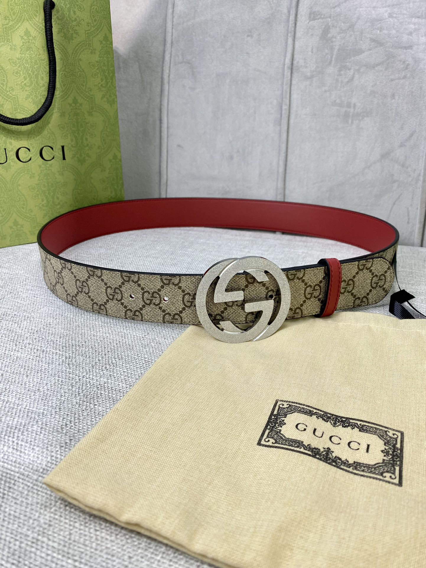 Gucci belt with GG canvas, red leather edge, round silver-toned interlocking buckle