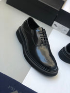 Black polished lace-up shoe with brogue perforations and low profile sole