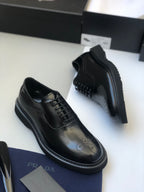 Black lace-up oxford shoes with side panel stitching and thick rubber sole