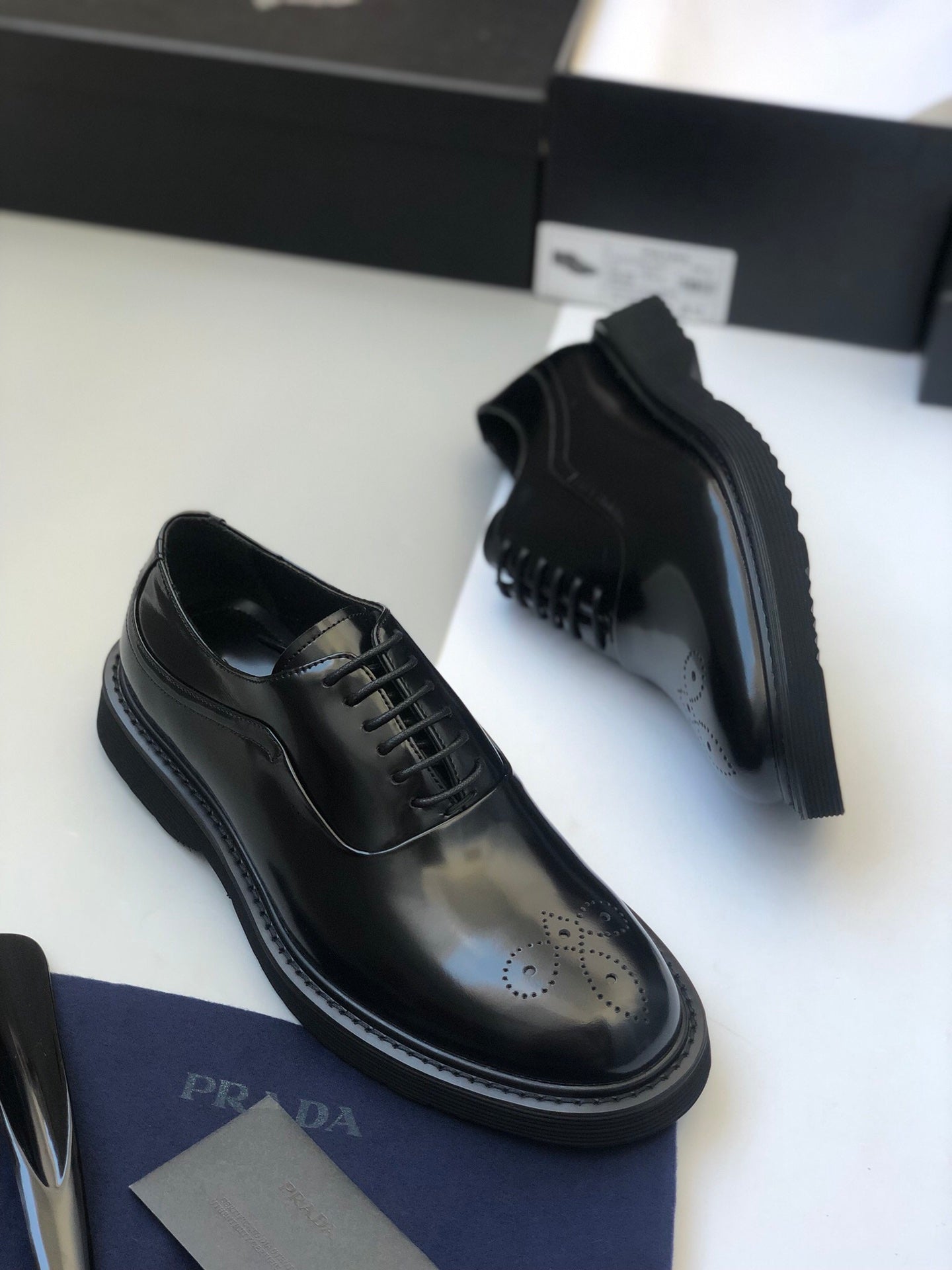 Black lace-up oxford shoes with side panel stitching and thick rubber sole