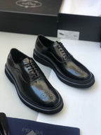 Pair of black lace-up dress shoes with brogue perforations and flat sole
