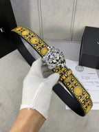 Designer belt with black strap, gold patterned trim, and large silver lion buckle